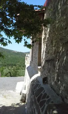 a stone building with a cat sitting on the wall at Traditional House Koukounara in Kissamos
