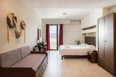 a bedroom with a bed and a couch in a room at Mirtilos Studios & Apartments in Kissamos
