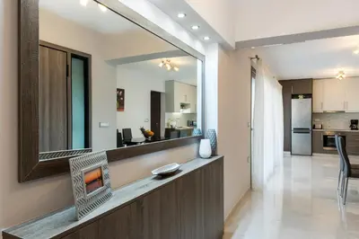 a living room and kitchen with a fireplace in a house at Jasmine in Maleme