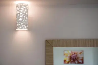 a light fixture on a wall next to a picture at Mimosa in Maleme