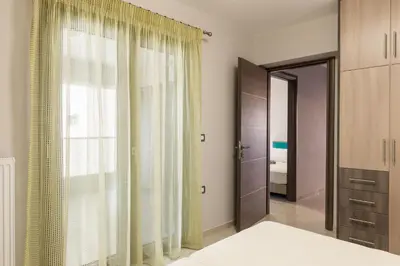 a bedroom with a bed and a large window at Mimosa in Maleme