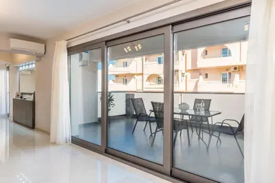 a dining room with glass doors and a table at Mimosa in Maleme