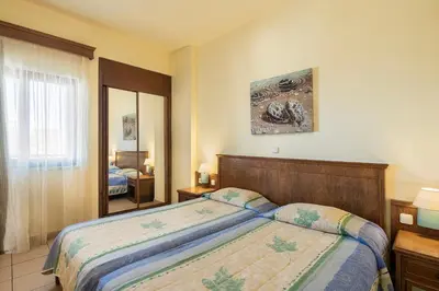 a bedroom with a bed and a window and a mirror at Indigo Mare in Plataniás