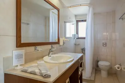 a bathroom with a sink and a toilet and a mirror at Indigo Mare in Plataniás