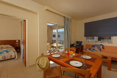 a living room with a dining room table and a couch at Indigo Mare in Plataniás