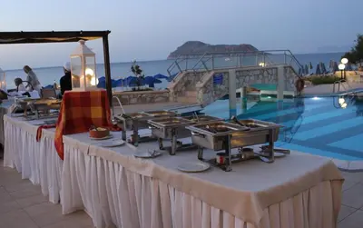 a table with food on it next to a pool at Indigo Mare in Plataniás