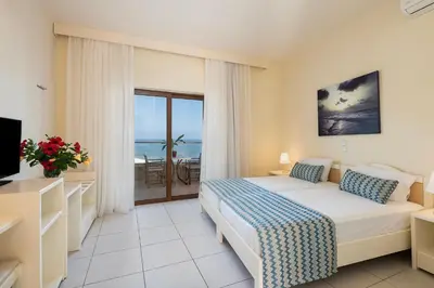 a bedroom with a bed and a view of the ocean at Indigo Mare in Plataniás