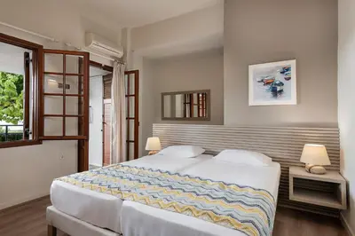 a bedroom with two beds and a window at Alianthos Suites in Tersanas