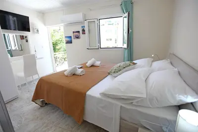 a bedroom with a large bed with a orange blanket at Nea Chora Maisonette in Chania Town