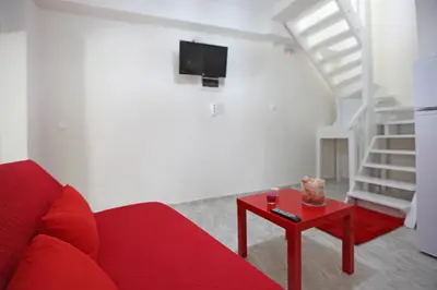 a living room with a red couch and a red table at Nea Chora Maisonette in Chania Town
