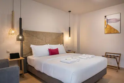 a bedroom with a large white bed with red pillows at Trianon Luxury Apartments & Suites in Chania Town