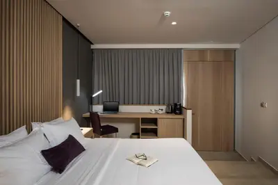 a hotel room with a bed and a desk with a computer at Trianon Luxury Apartments & Suites in Chania Town