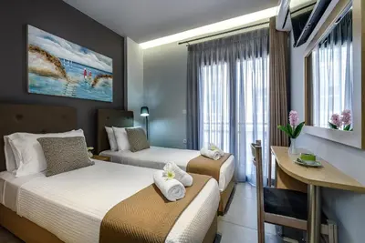 a hotel room with two beds and a desk at City Breeze Apartment in Chania Town