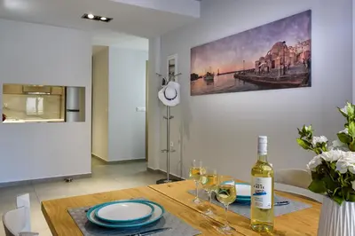 a dining room with a table with a bottle of wine at City Breeze Apartment in Chania Town