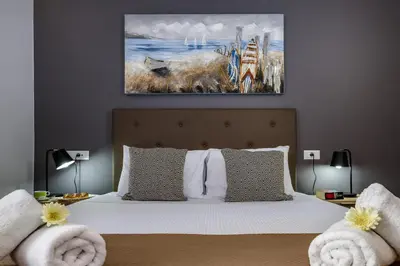 a bedroom with a bed with a painting on the wall at City Breeze Apartment in Chania Town