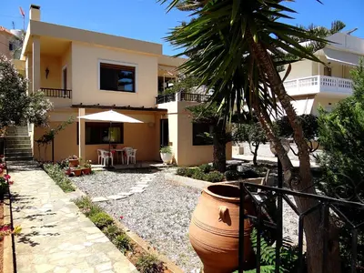 a house with a palm tree in front of it at Apartment by the Sea in Kato Daratso