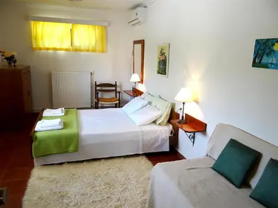 a hotel room with two beds and a couch at Apartment by the Sea in Kato Daratso