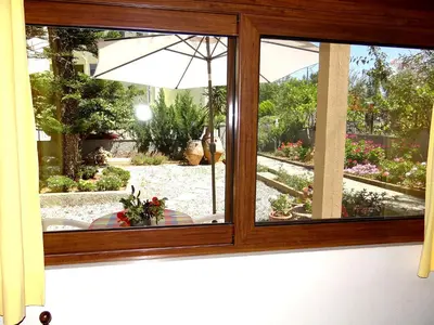 a window view of a garden with an umbrella at Apartment by the Sea in Kato Daratso
