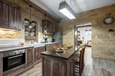 a kitchen with wooden cabinets and a counter top at Villa Aerino in Azoyirás