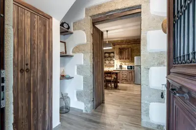a hallway with a stone wall and a wooden door at Villa Aerino in Azoyirás