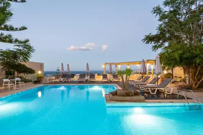 a swimming pool with chaise lounges and chairs at Aphea Village in Kolymvari