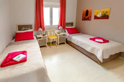 two beds in a room with red towels on them at Skandalakis Homes & Apartments in Stalos