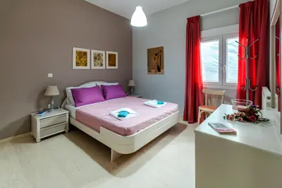 a bedroom with a large bed with purple pillows at Skandalakis Homes & Apartments in Stalos