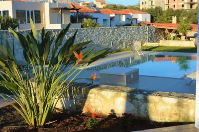 a swimming pool with a bench next to a house at The Well in Chorafakia