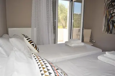 a bedroom with a white bed with a window at The Well in Chorafakia