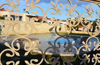 a metal gate with a reflection of a building at The Well in Chorafakia