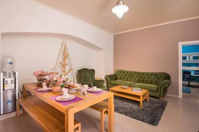 a living room with a table and a green couch at Casa Arokaria in Pendarianá
