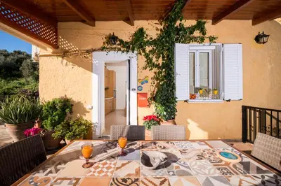 a patio with a table and chairs and a window at Casa Arokaria in Pendarianá