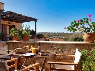 a patio with a table and chairs on a stone wall at Fabrica in Vamos