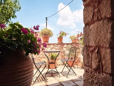 a patio with chairs and potted plants on a wall at Fabrica in Vamos