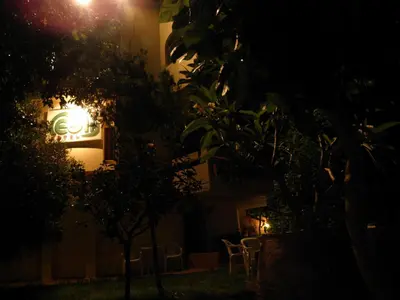 a building with chairs and a lit up sign at night at Megim Hotel in Palaiochóra