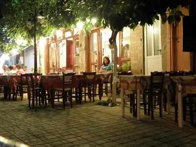 a woman sitting at a table in a restaurant at Megim Hotel in Palaiochóra