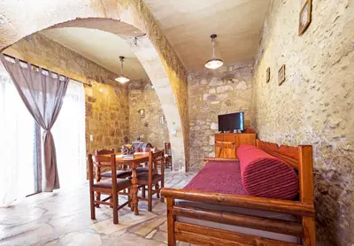 a room with a bed and a table and chairs at Petrakis Cretan Homes in Kissamos
