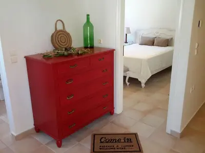 a red dresser in a bedroom with a bed at Rena House in Kissamos