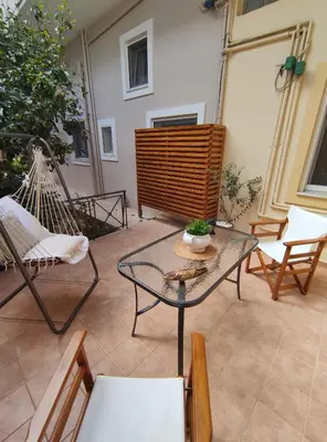 a patio with a hammock and a table and chairs at Rena House in Kissamos