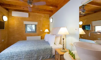 a bedroom with a bed and a bathroom with a sink at Olea Prime in Marathi