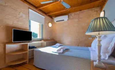 a bedroom with a bed with a lamp and a tv at Olea Prime in Marathi