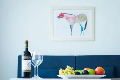 a bottle of wine and a plate of fruit and a wine glass at Silver Beach Hotel & Apartments in Gerani Chanion