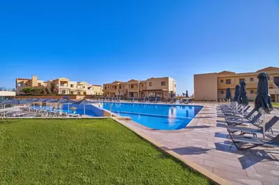 a large swimming pool with lounge chairs and umbrellas at Silver Beach Hotel & Apartments in Gerani Chanion