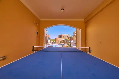 a large blue ping pong table in a room with a window at Silver Beach Hotel & Apartments in Gerani Chanion