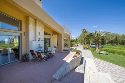 a house with a patio with a table and chairs at Gea Maleme in Maleme