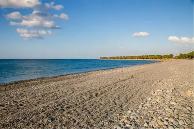 a beach with a rocky shoreline and the ocean at San Antonio Apartments in Kolymvari