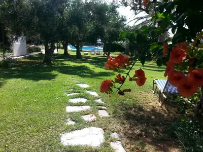 a stepping stone path in a park with a bench at Viena Rooms & Apartments in Palaiochóra