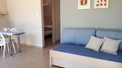 a blue couch in a room with a table at Viena Rooms & Apartments in Palaiochóra