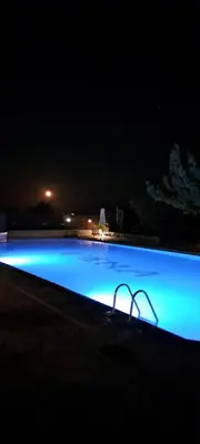 a large swimming pool lit up at night at Viena Rooms & Apartments in Palaiochóra