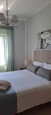 a bedroom with a large white bed and a window at Viena Rooms & Apartments in Palaiochóra